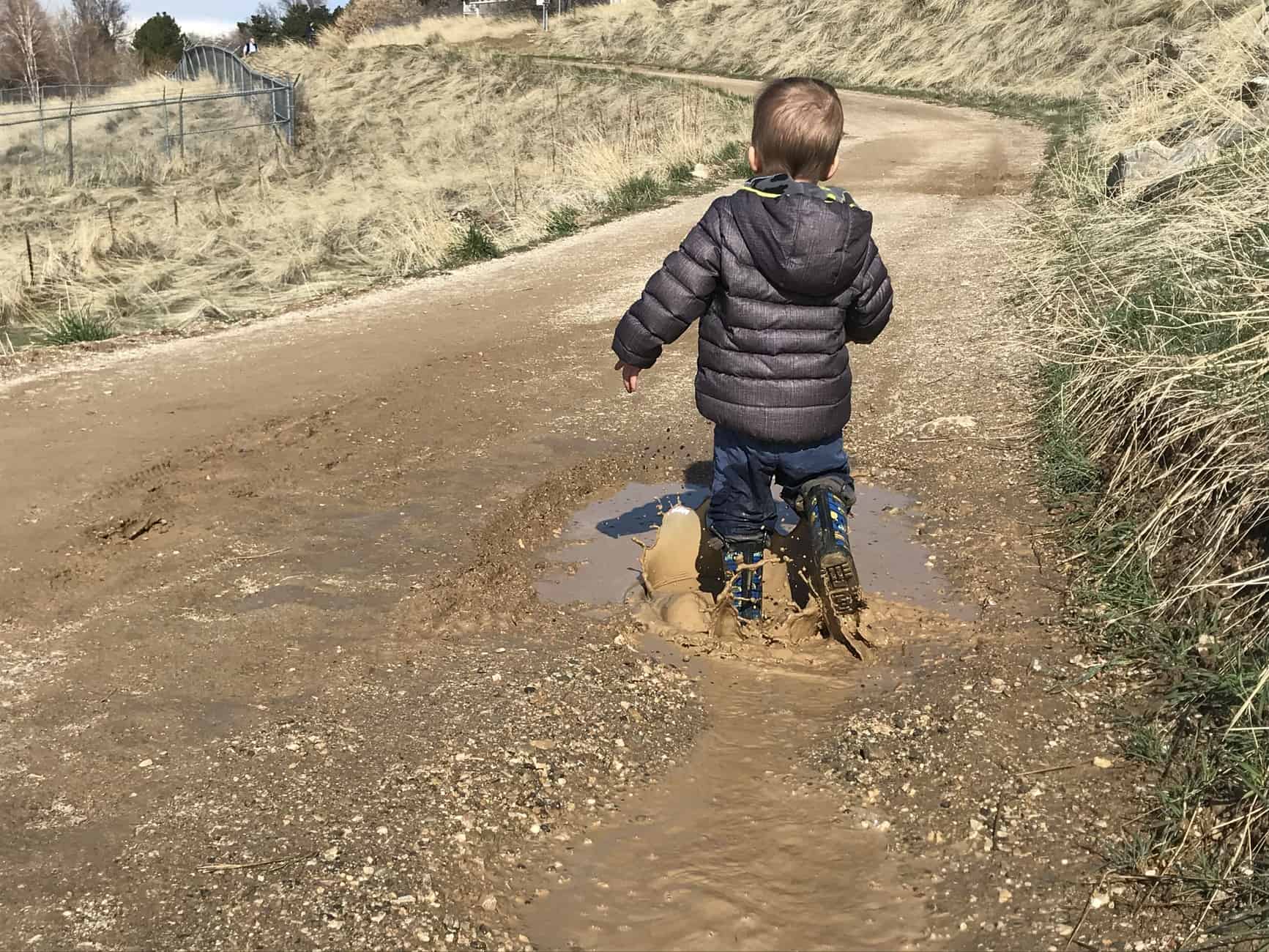 boy walking through puddle
